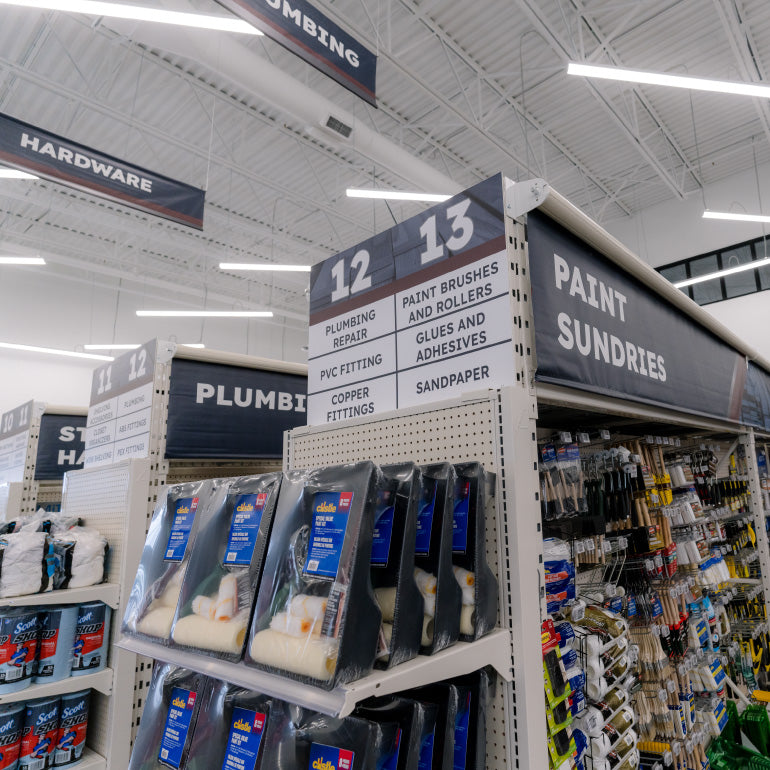 Paint and sundries aisle in Adams Building Supply showcasing signage and rollup banners